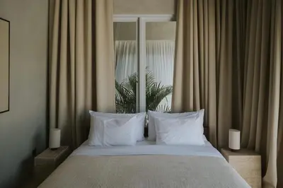 a bed with white pillows in front of a window at Designer 3BR Villa Tropical Stay Near Canggu in Kerobokan