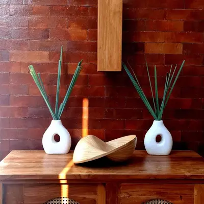 three white vases sitting on a wooden table with plants at Villa Anoli - 3 chambres - Centre de Seminyak in Seminyak