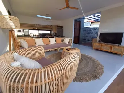a living room with two wicker chairs and a television at Villa Anoli - 3 chambres - Centre de Seminyak in Seminyak