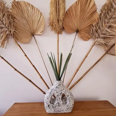 a vase sitting on a table with dried grass at Villa Anoli - 3 chambres - Centre de Seminyak in Seminyak