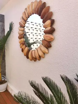 a circular mirror on a wall with a plant at Villa Anoli - 3 chambres - Centre de Seminyak in Seminyak