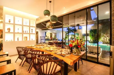 a dining room with a long wooden table and chairs at Splendid Villa 3Br 200m to the Brawah beach in Canggu