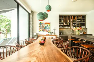 a dining room with a large wooden table and chairs at Splendid Villa 3Br 200m to the Brawah beach in Canggu
