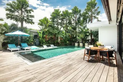a pool with a table and chairs next to a house at Splendid Villa 3Br 200m to the Brawah beach in Canggu
