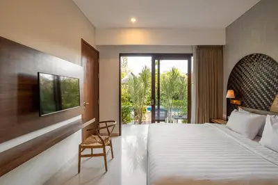 a bedroom with a king sized bed and a balcony at Cove Tevana in Seminyak