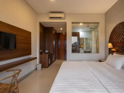 a bedroom with a large bed and a television at Cove Tevana in Seminyak