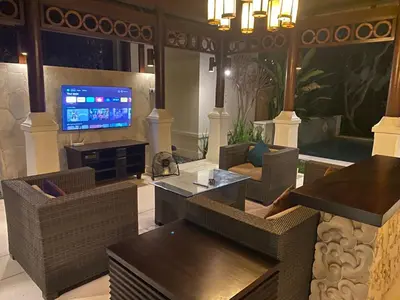 a living room with couches and a flat screen tv at Jimbaran BeachStroll Villa (2BR) in Jimbaran