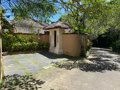a small building with a roof on a brick yard at Jimbaran BeachStroll Villa (2BR) in Jimbaran