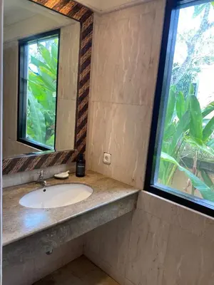a bathroom with a sink and a mirror at Jimbaran BeachStroll Villa (2BR) in Jimbaran