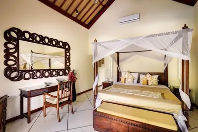 a bedroom with a canopy bed and a desk and a mirror at Villa Mango - 3 Bedroom Villa in Seminyak in Seminyak