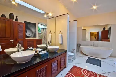 a bathroom with two sinks and a tub and a toilet at Villa Mango - 3 Bedroom Villa in Seminyak in Seminyak