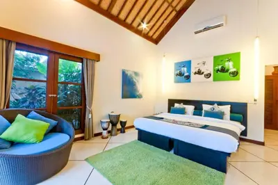 a bedroom with a bed and a couch and a window at Villa Mango - 3 Bedroom Villa in Seminyak in Seminyak