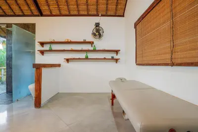 a room with a table and shelves on the wall at Villa Elyse Seminyak in Seminyak