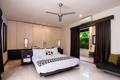 a bedroom with a large bed and a large window at Villa Spirit 4 BR - Canggu in Canggu