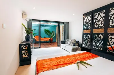 a bedroom with a bed and an orange couch at Bali Adua Villa in Seminyak
