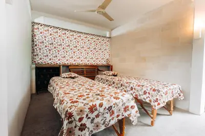 a room with two beds and a ceiling at Bali Adua Villa in Seminyak