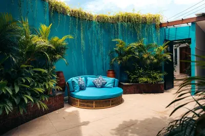 a blue couch on a patio with plants at Bali Adua Villa in Seminyak