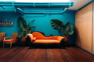 an orange couch in a room with two plants at Bali Adua Villa in Seminyak