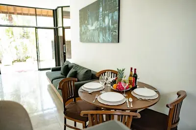 a dining room with a table and a couch at Saga Villas Oasis in Seminyak