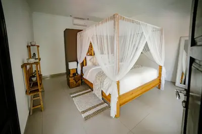 a bedroom with two beds with mosquito nets at Saga Villas Oasis in Seminyak
