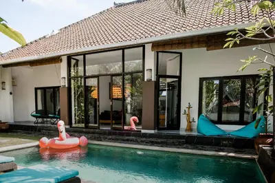 a house with a swimming pool with inflatable toys in it at Saga Villas Oasis in Seminyak