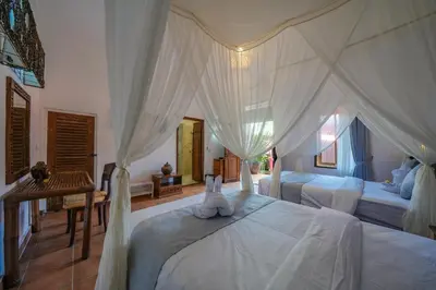 a bedroom with two beds with white drapes at Huge 2 Bedroom private pool Villa - Gong Zhu Camille in Pesanggaran