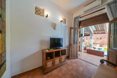 a living room with a tv on a wooden entertainment center at Huge 2 Bedroom private pool Villa - Gong Zhu Camille in Pesanggaran