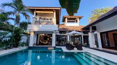 a house with a swimming pool in front of a house at Cempaka Villa by Premier Hospitality Asia in Nusa Dua