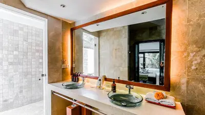 a bathroom with two sinks and a large mirror at Cempaka Villa by Premier Hospitality Asia in Nusa Dua