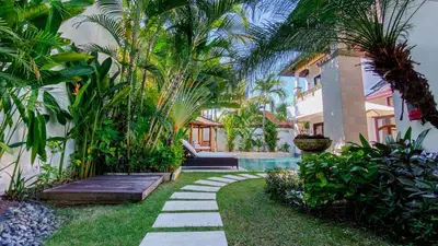 a garden with a walkway next to a house at Cempaka Villa by Premier Hospitality Asia in Nusa Dua