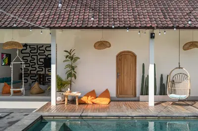 a villa with a swimming pool and a house at SHAKA CLAN SURF in Canggu