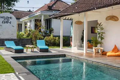 a swimming pool in the backyard of a house with blue chairs at SHAKA CLAN SURF in Canggu