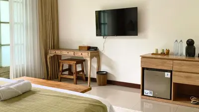 a bedroom with a bed and a tv on the wall at White Penny Hostel in Seminyak