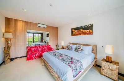 a bedroom with a large white bed with red furniture at Villa Olli in Seminyak