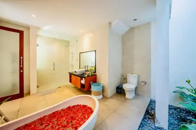 a bathroom with a bath tub and a toilet at Villa Olli in Seminyak