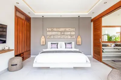 a bedroom with a white bed and wooden accents at Luxurious 6 Br in Canggu 400m to Finns Beach in Canggu