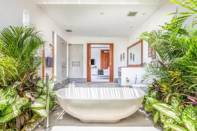 a bath tub in a room with plants at Luxurious 6 Br in Canggu 400m to Finns Beach in Canggu