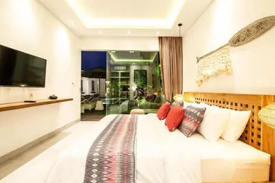 a bedroom with a large white bed with red pillows at Luxurious 6 Br in Canggu 400m to Finns Beach in Canggu