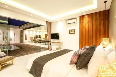 a bedroom with a large bed and a living room at Luxurious 6 Br in Canggu 400m to Finns Beach in Canggu