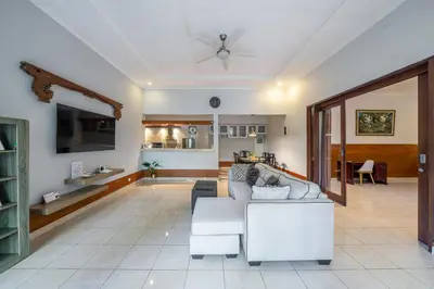 a living room with a white couch and a tv at Nameera Villa in Seminyak