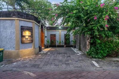 a brick walkway leading to a house with a tree at Nameera Villa in Seminyak