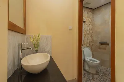 a bathroom with a sink and a toilet at Liliy Guest House Kuta in Legian