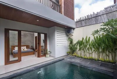 a house with a swimming pool next to a bedroom at Vpas Villa in Seminyak