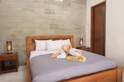 a bedroom with a bed with swans on it at Vpas Villa in Seminyak