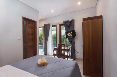 a bedroom with a bed and a table and chairs at Vpas Villa in Seminyak