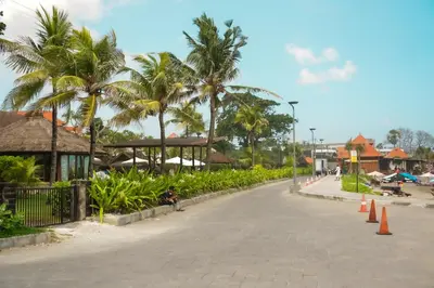 a street with palm trees on the side of a road at Tropical Beach House Bali in Seminyak