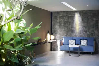 a living room with a blue couch and some plants at New Luxury Villa Adamare 1 in Kerobokan