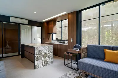 a living room with a blue couch and a kitchen at New Luxury Villa Adamare 1 in Kerobokan