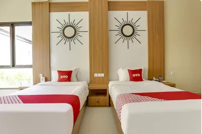 two beds in a room with sun stickers on the wall at Moreno Homestay in Legian