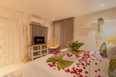 a bedroom with a bed with flowers on it at Villa Burung in Kashantee Village in Seminyak
